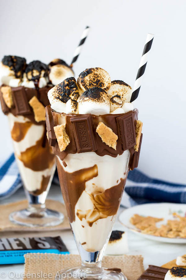 Give me S’mores Milkshake — milk chocolate and graham cracker decorated glass filled with a toasted marshmallow milkshake and topped with charred marshmallows! 