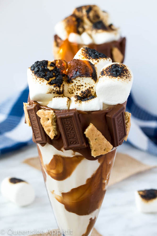 Give me S’mores Milkshake — milk chocolate and graham cracker decorated glass filled with a toasted marshmallow milkshake and topped with charred marshmallows! 