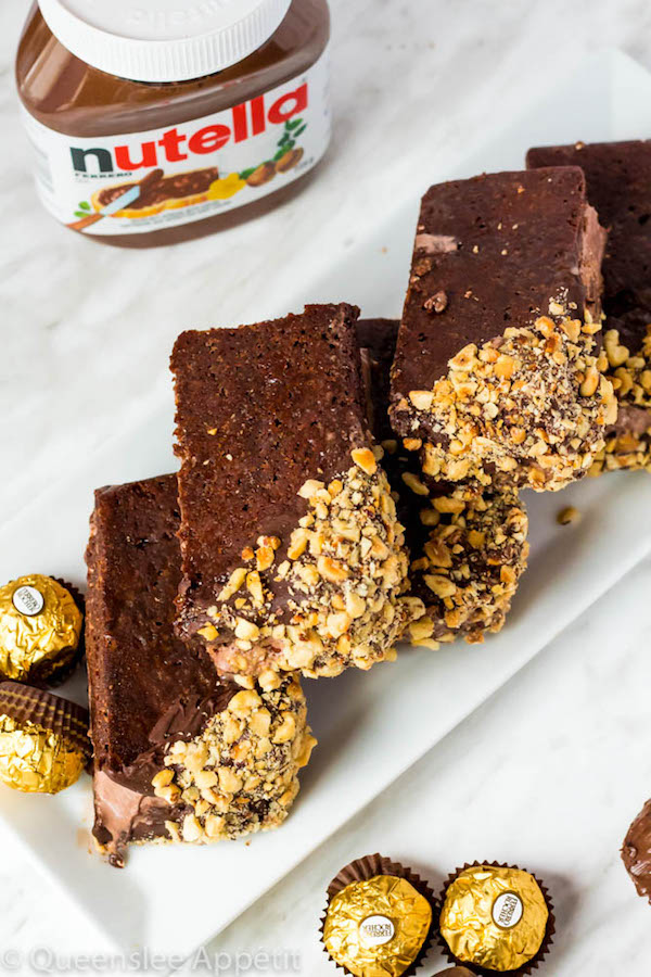 These Nutella Brownie Ice Cream Sandwiches feature Ferrero Rocher stuffed chocolate ice cream sandwiched between two fudgy Nutella brownies. These lovelies are taken to the next level with a chocolate/hazelnut coating! A fun treat for the summertime! 