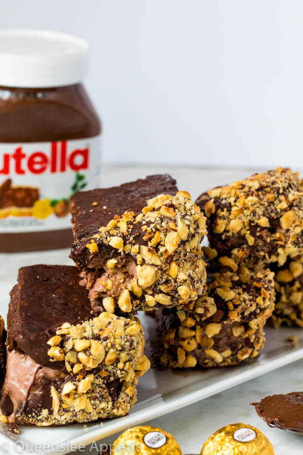 These Nutella Brownie Ice Cream Sandwiches feature Ferrero Rocher stuffed chocolate ice cream sandwiched between two fudgy Nutella brownies. These lovelies are taken to the next level with a chocolate/hazelnut coating! A fun treat for the summertime! 