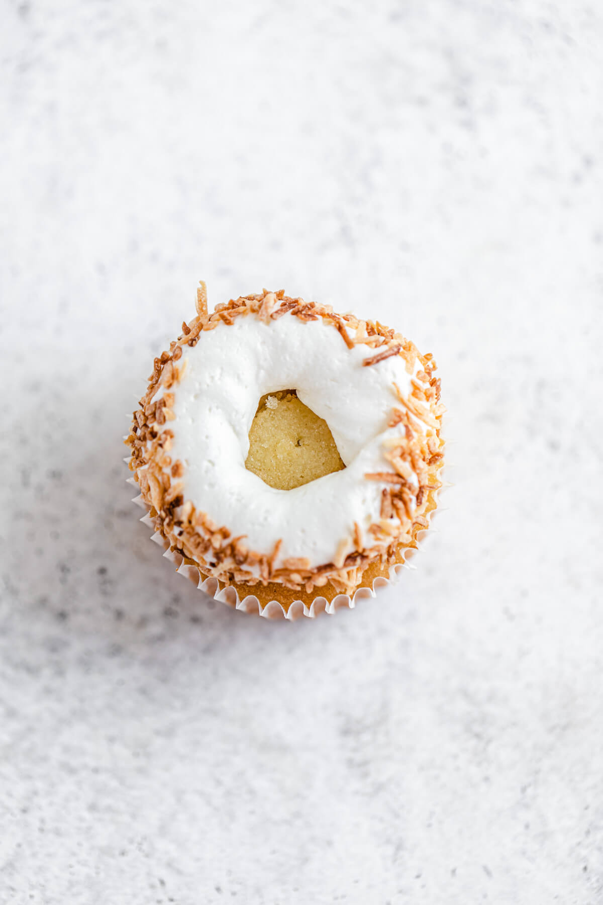 rim of coconut dipped frosting on a cupcake
