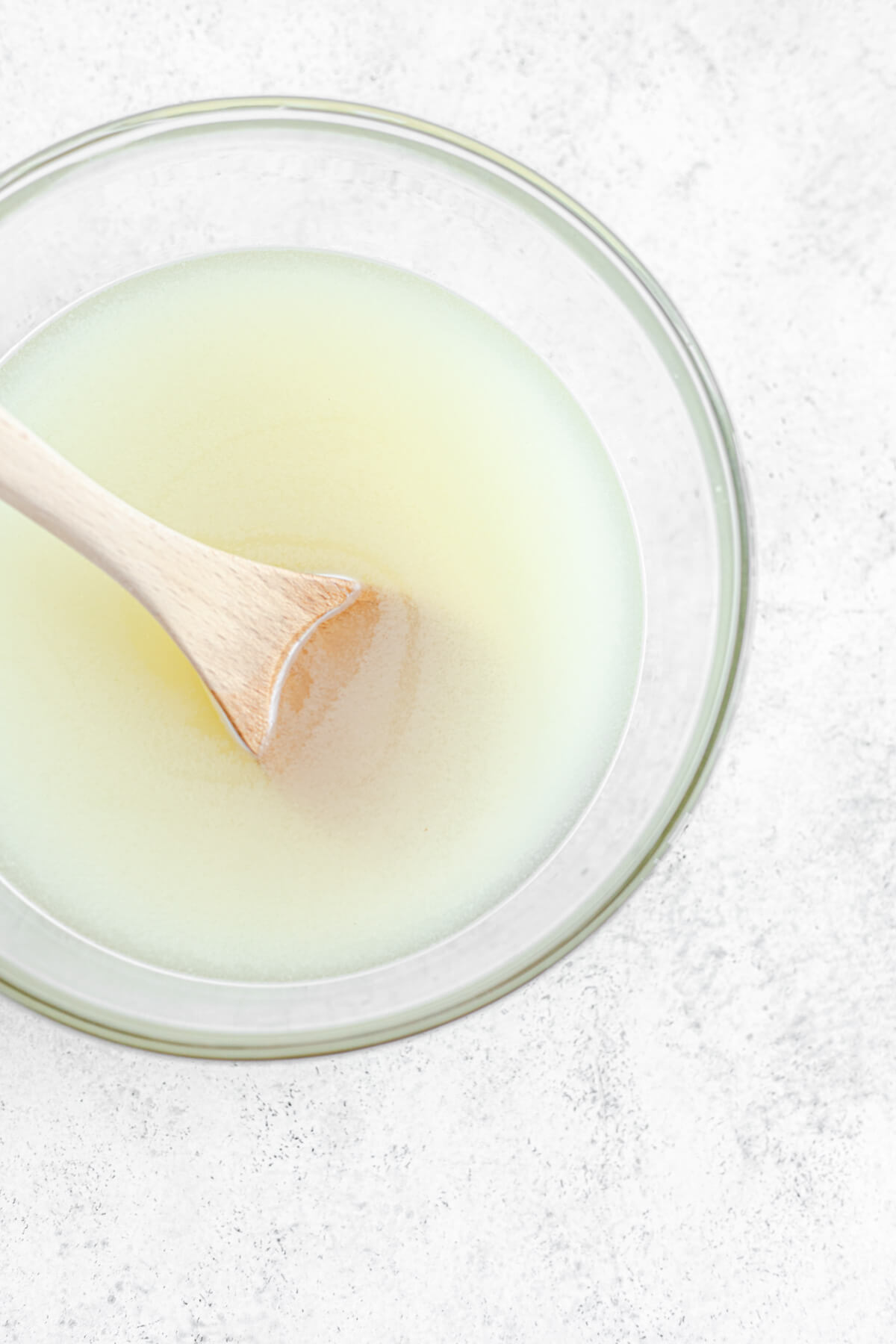 lemonade in a glass bowl with a wooden spoon