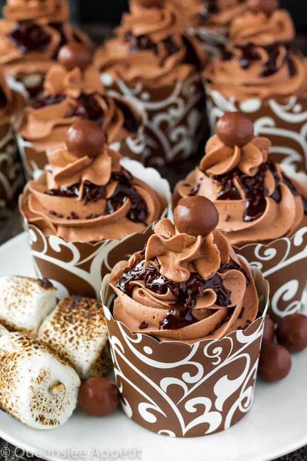 Malted Belgian Chocolate Cupcakes featuring moist malt chocolate cupcakes with a malted milk chocolate Belgian buttercream frosting and a surprise toasted marshmallow filling. Top these cupcakes off with a rich chocolate ganache, chocolate sprinkles and a malteeser candy for a fun summer treat! 