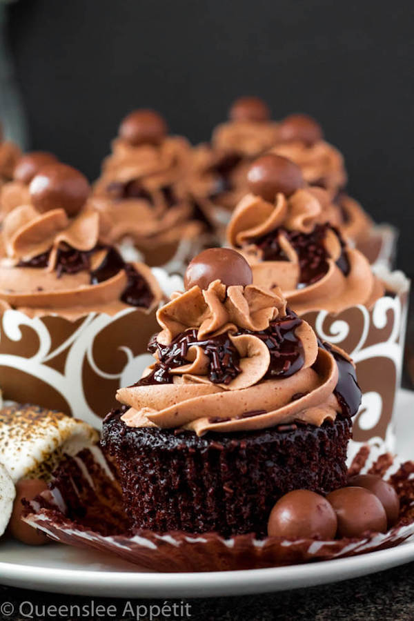 Malted Belgian Chocolate Cupcakes featuring moist malt chocolate cupcakes with a malted milk chocolate Belgian buttercream frosting and a surprise toasted marshmallow filling. Top these cupcakes off with a rich chocolate ganache, chocolate sprinkles and a malteeser candy for a fun summer treat! 