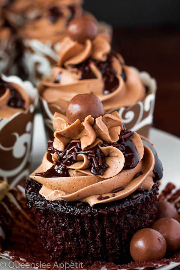 Malted Belgian Chocolate Cupcakes featuring moist malt chocolate cupcakes with a malted milk chocolate Belgian buttercream frosting and a surprise toasted marshmallow filling. Top these cupcakes off with a rich chocolate ganache, chocolate sprinkles and a malteeser candy for a fun summer treat! 