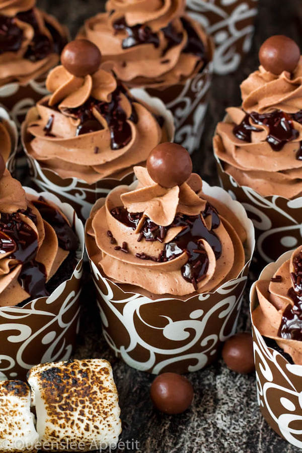 Malted Belgian Chocolate Cupcakes featuring moist malt chocolate cupcakes with a malted milk chocolate Belgian buttercream frosting and a surprise toasted marshmallow filling. Top these cupcakes off with a rich chocolate ganache, chocolate sprinkles and a malteeser candy for a fun summer treat! 