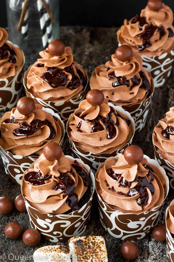 Malted Belgian Chocolate Cupcakes featuring moist malt chocolate cupcakes with a malted milk chocolate Belgian buttercream frosting and a surprise toasted marshmallow filling. Top these cupcakes off with a rich chocolate ganache, chocolate sprinkles and a malteeser candy for a fun summer treat! 