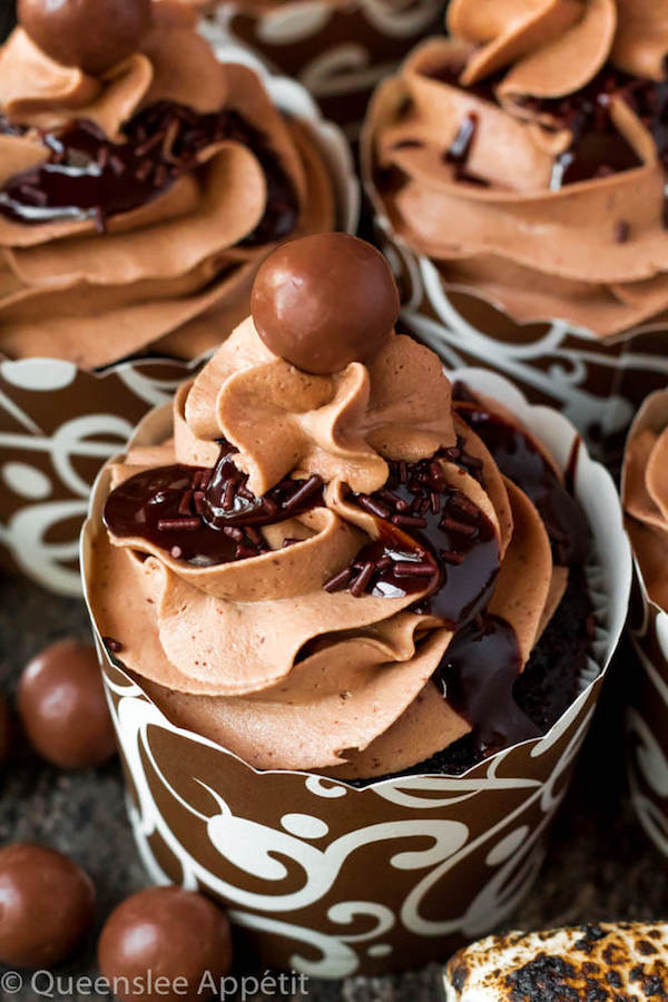 Malted Belgian Chocolate Cupcakes featuring moist malt chocolate cupcakes with a malted milk chocolate Belgian buttercream frosting and a surprise toasted marshmallow filling. Top these cupcakes off with a rich chocolate ganache, chocolate sprinkles and a malteeser candy for a fun summer treat! 