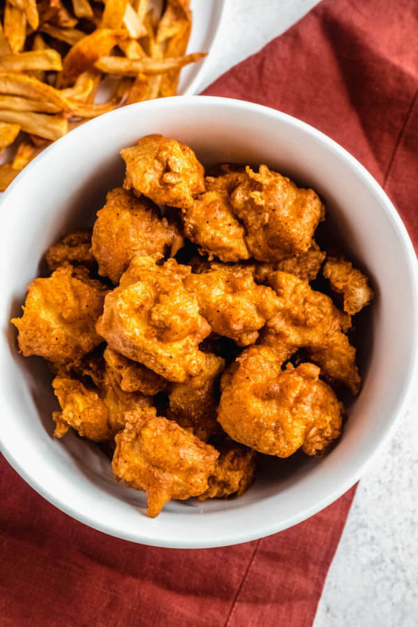 bowl of crispy chicken nuggets with fries on the side