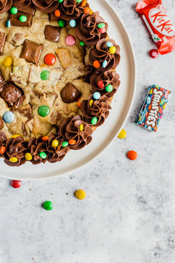 cookie cake loaded with halloween candy and topped with chocolate buttercream