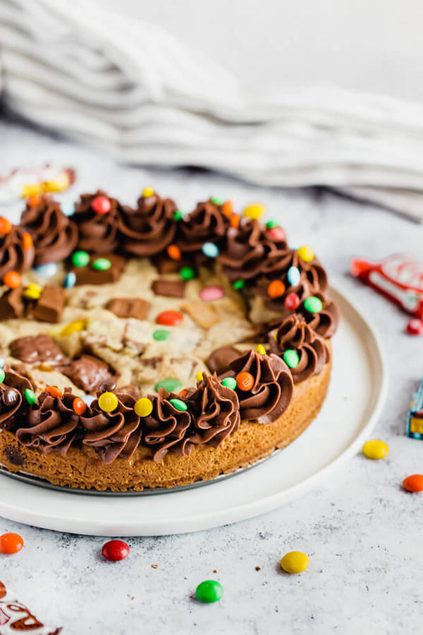 cookie cake loaded with halloween candy and topped with chocolate buttercream