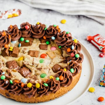 cookie cake loaded with halloween candy and topped with chocolate buttercream