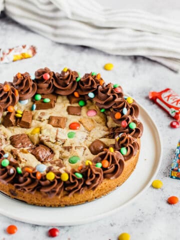 cookie cake loaded with halloween candy and topped with chocolate buttercream