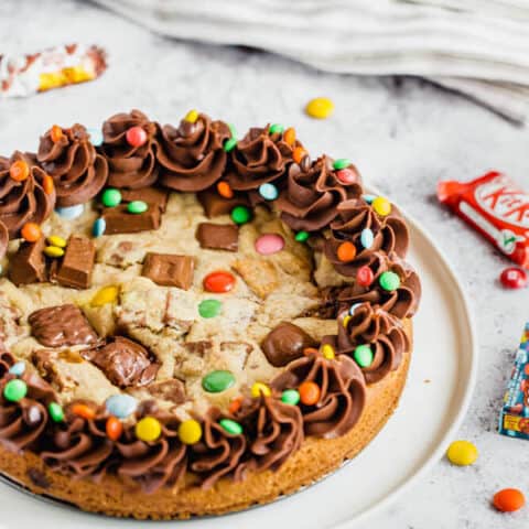 cookie cake loaded with halloween candy and topped with chocolate buttercream