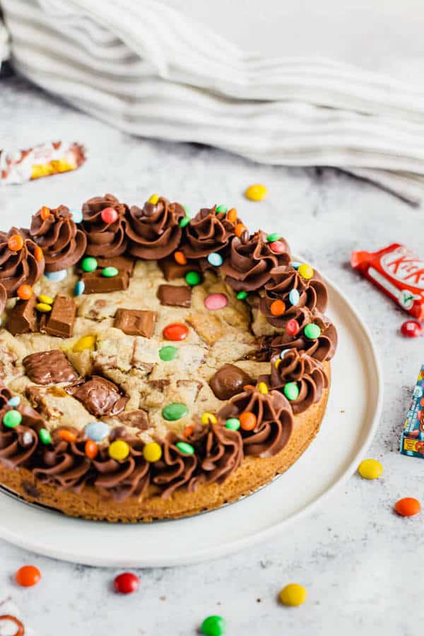 cookie cake loaded with halloween candy and topped with chocolate buttercream