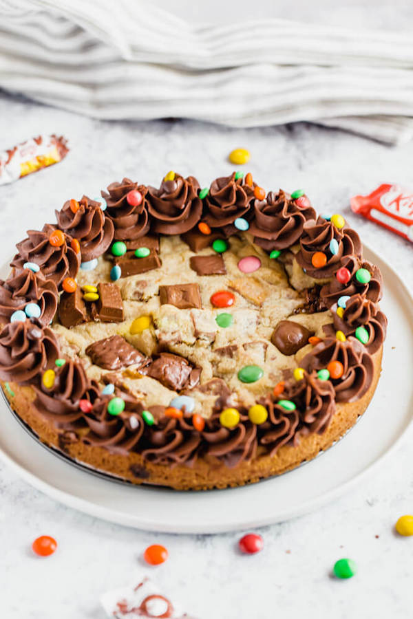 cookie cake loaded with halloween candy and topped with chocolate buttercream