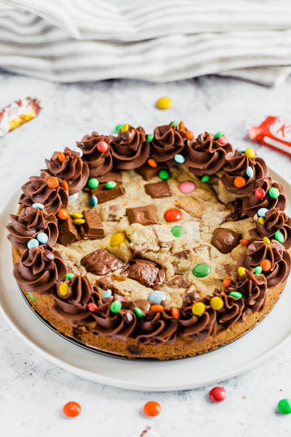 cookie cake loaded with halloween candy and topped with chocolate buttercream