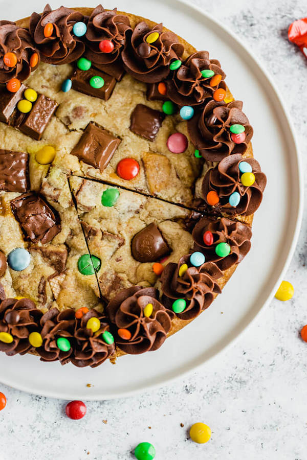 cookie cake loaded with halloween candy and topped with chocolate buttercream