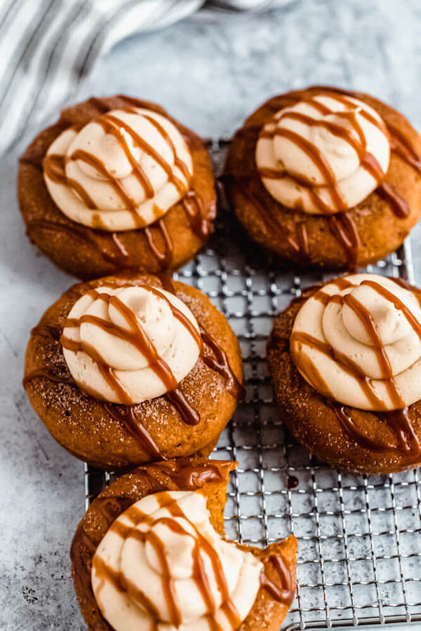 pumpkin donuts topped with salted caramel cream cheese frosting and salted caramel sauce drizzle on a safety grater