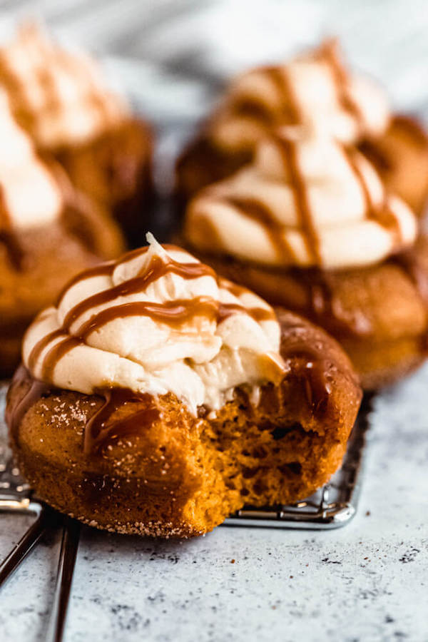 pumpkin donuts topped with salted caramel cream cheese frosting and salted caramel sauce drizzle 