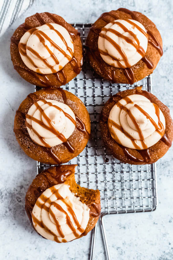 pumpkin donuts topped with salted caramel cream cheese frosting and salted caramel sauce drizzle on a safety grater