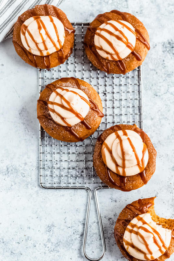 pumpkin donuts topped with salted caramel cream cheese frosting and salted caramel sauce drizzle on a safety grater