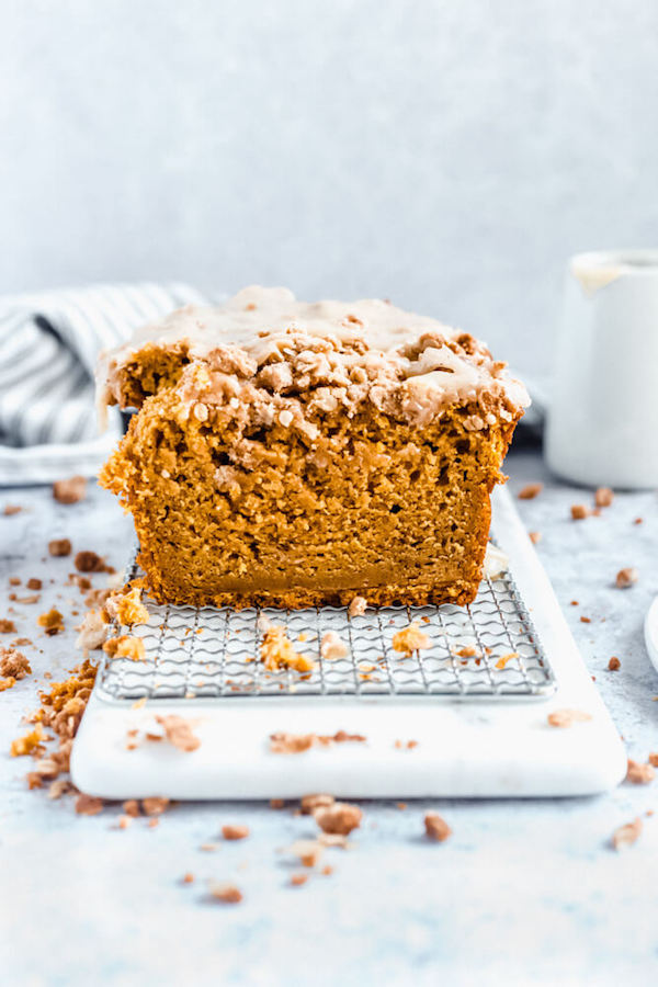 half of pumpkin streusel bread on a board