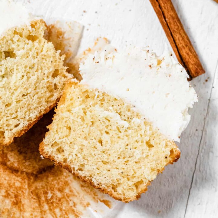 halved cupcakes on a cupcake liner with two cinnamon sticks above them