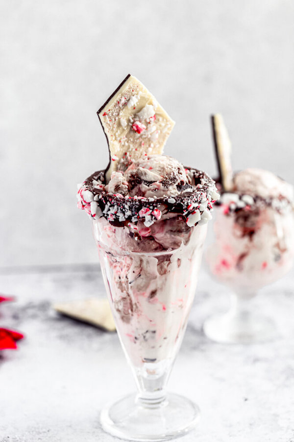 two glasses of peppermint bark ice cream with candy cane rim