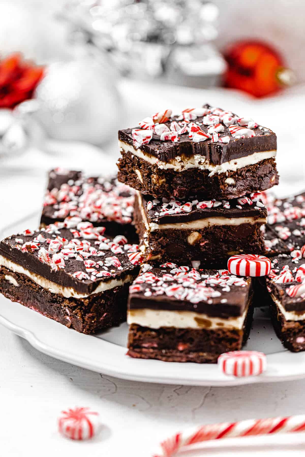 brownies stacked on a white plate with bite taken out of top brownie