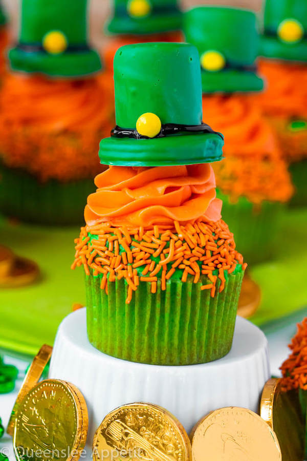 These Leprechaun Hat Cupcakes are super adorable and fun to make! A moist green vanilla cupcake stuffed with gold sprinkles, topped with a fluffy green and orange vanilla frosting and a cute little leprechaun hat sitting on top! This is the ultimate St. Patrick’s Day treat!