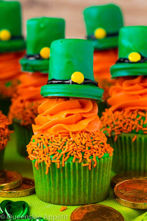 These Leprechaun Hat Cupcakes are super adorable and fun to make! A moist green vanilla cupcake stuffed with gold sprinkles, topped with a fluffy green and orange vanilla frosting and a cute little leprechaun hat sitting on top! This is the ultimate St. Patrick’s Day treat!