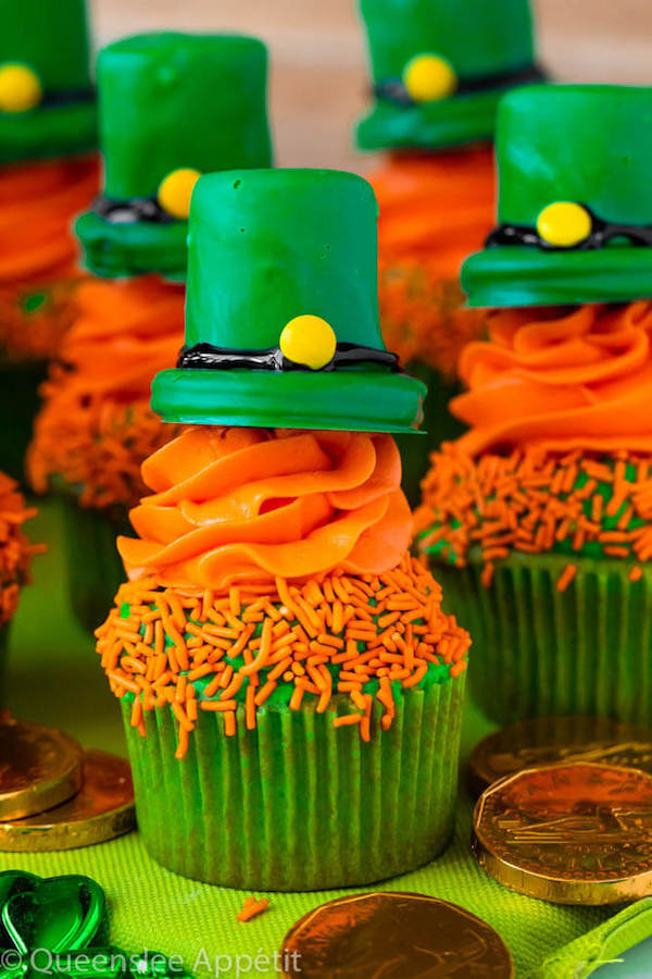 These Leprechaun Hat Cupcakes are super adorable and fun to make! A moist green vanilla cupcake stuffed with gold sprinkles, topped with a fluffy green and orange vanilla frosting and a cute little leprechaun hat sitting on top! This is the ultimate St. Patrick’s Day treat!