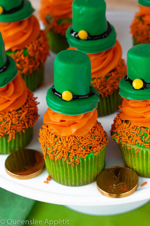 These Leprechaun Hat Cupcakes are super adorable and fun to make! A moist green vanilla cupcake stuffed with gold sprinkles, topped with a fluffy green and orange vanilla frosting and a cute little leprechaun hat sitting on top! This is the ultimate St. Patrick’s Day treat!