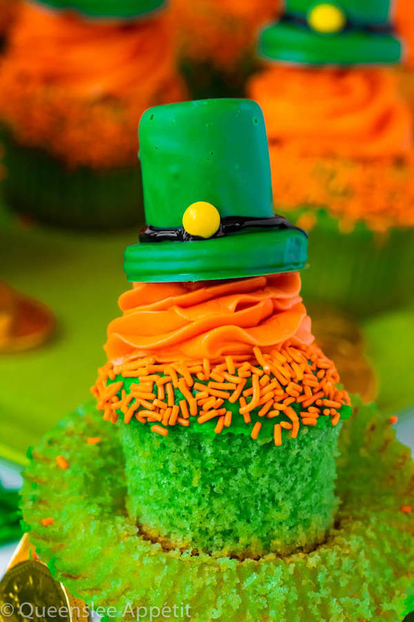 These Leprechaun Hat Cupcakes are super adorable and fun to make! A moist green vanilla cupcake stuffed with gold sprinkles, topped with a fluffy green and orange vanilla frosting and a cute little leprechaun hat sitting on top! This is the ultimate St. Patrick’s Day treat!