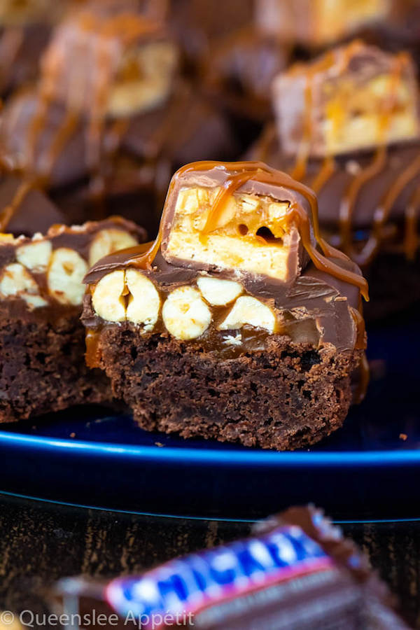 These Snickers Brownie Bites are made with pre-made brownie bites that are topped with a homemade peanut caramel sauce, chocolate peanut butter topping, a fun-size snickers bar and a drizzle of more salted caramel sauce! Such a simple and delicious bite sized treat!