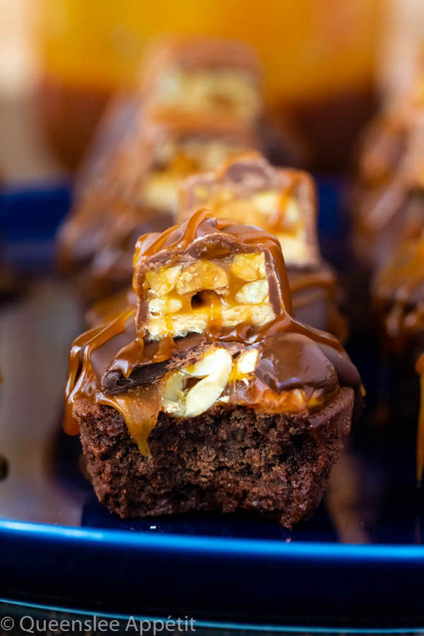 These Snickers Brownie Bites are made with pre-made brownie bites that are topped with a homemade peanut caramel sauce, chocolate peanut butter topping, a fun-size snickers bar and a drizzle of more salted caramel sauce! Such a simple and delicious bite sized treat!