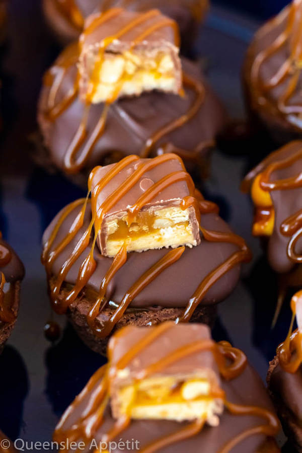 These Snickers Brownie Bites are made with pre-made brownie bites that are topped with a homemade peanut caramel sauce, chocolate peanut butter topping, a fun-size snickers bar and a drizzle of more salted caramel sauce! Such a simple and delicious bite sized treat!