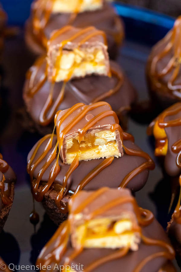 These Snickers Brownie Bites are made with pre-made brownie bites that are topped with a homemade peanut caramel sauce, chocolate peanut butter topping, a fun-size snickers bar and a drizzle of more salted caramel sauce! Such a simple and delicious bite sized treat!