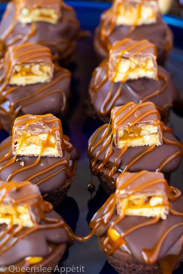 These Snickers Brownie Bites are made with pre-made brownie bites that are topped with a homemade peanut caramel sauce, chocolate peanut butter topping, a fun-size snickers bar and a drizzle of more salted caramel sauce! Such a simple and delicious bite sized treat!