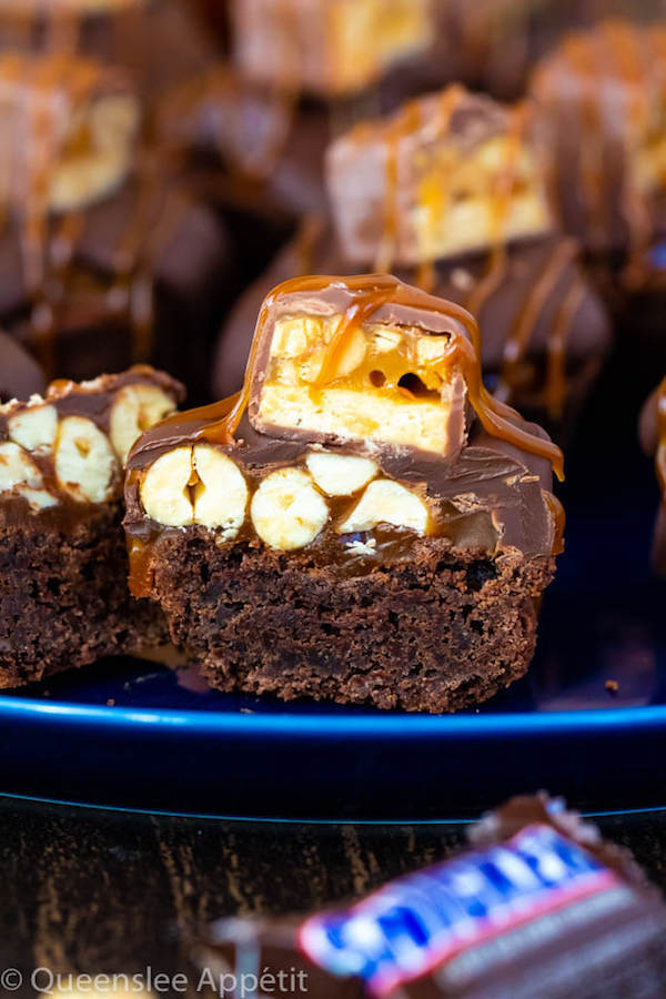 These Snickers Brownie Bites are made with pre-made brownie bites that are topped with a homemade peanut caramel sauce, chocolate peanut butter topping, a fun-size snickers bar and a drizzle of more salted caramel sauce! Such a simple and delicious bite sized treat!