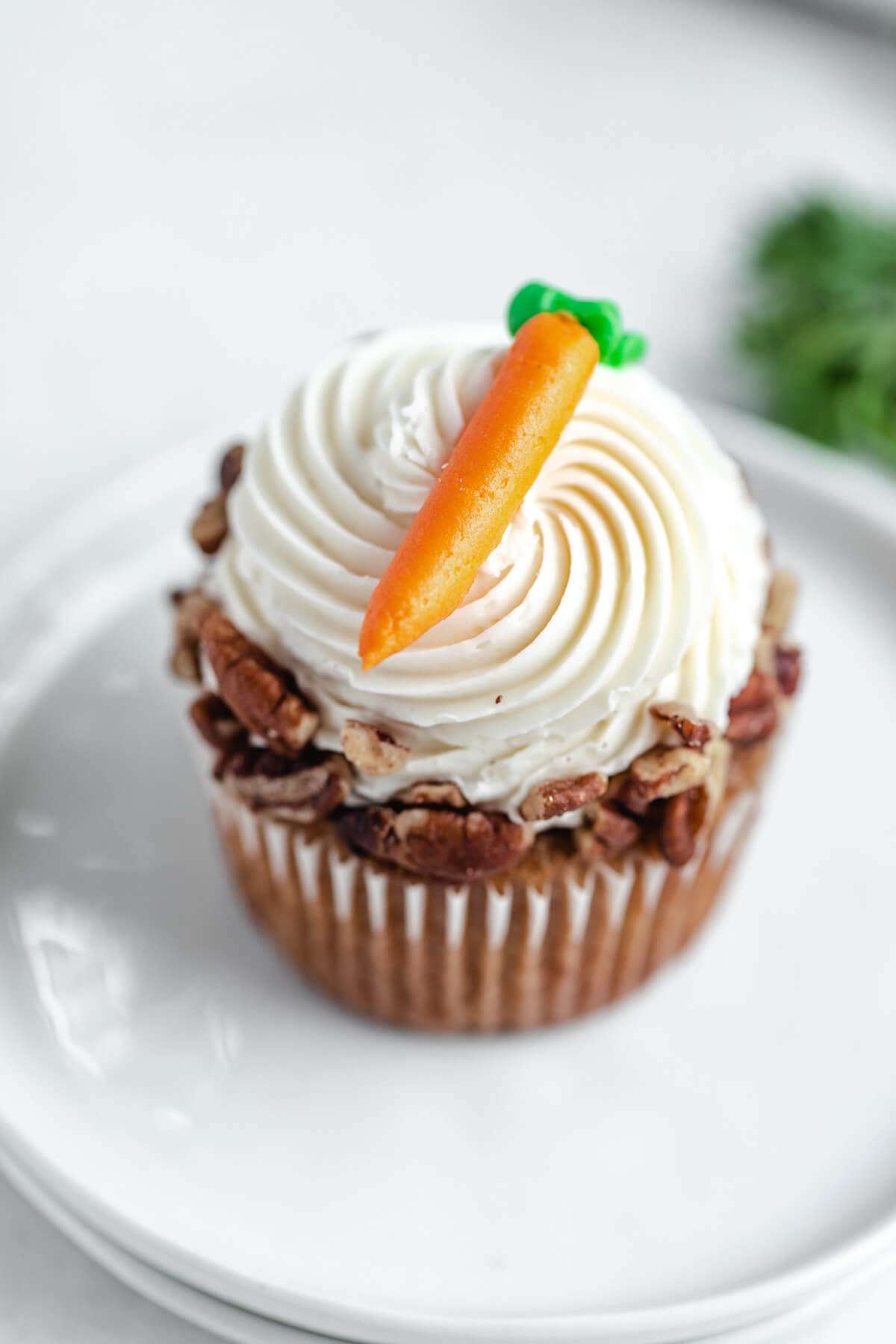 top angled close up of one cupcake on two white appetizer plates