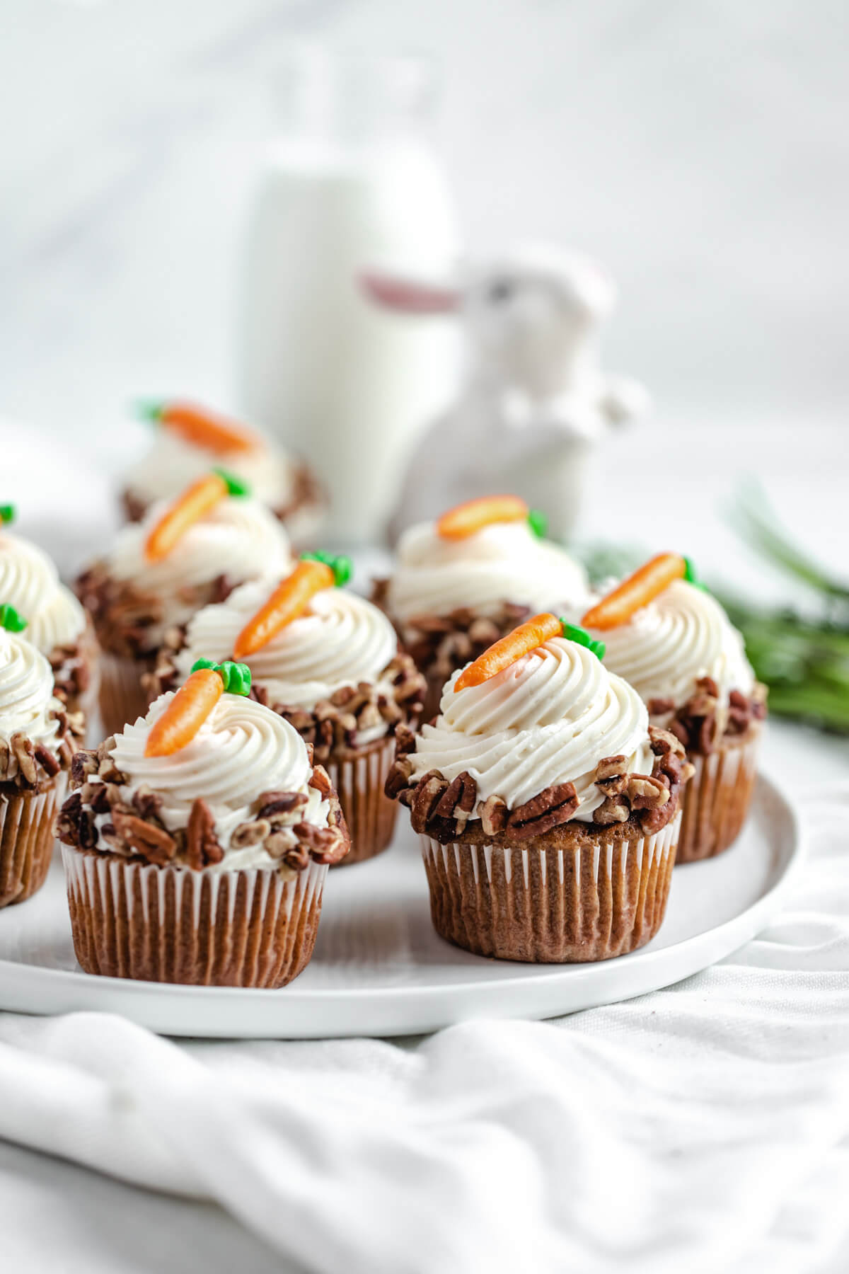 cupcakes on a white plate with carrots on top 