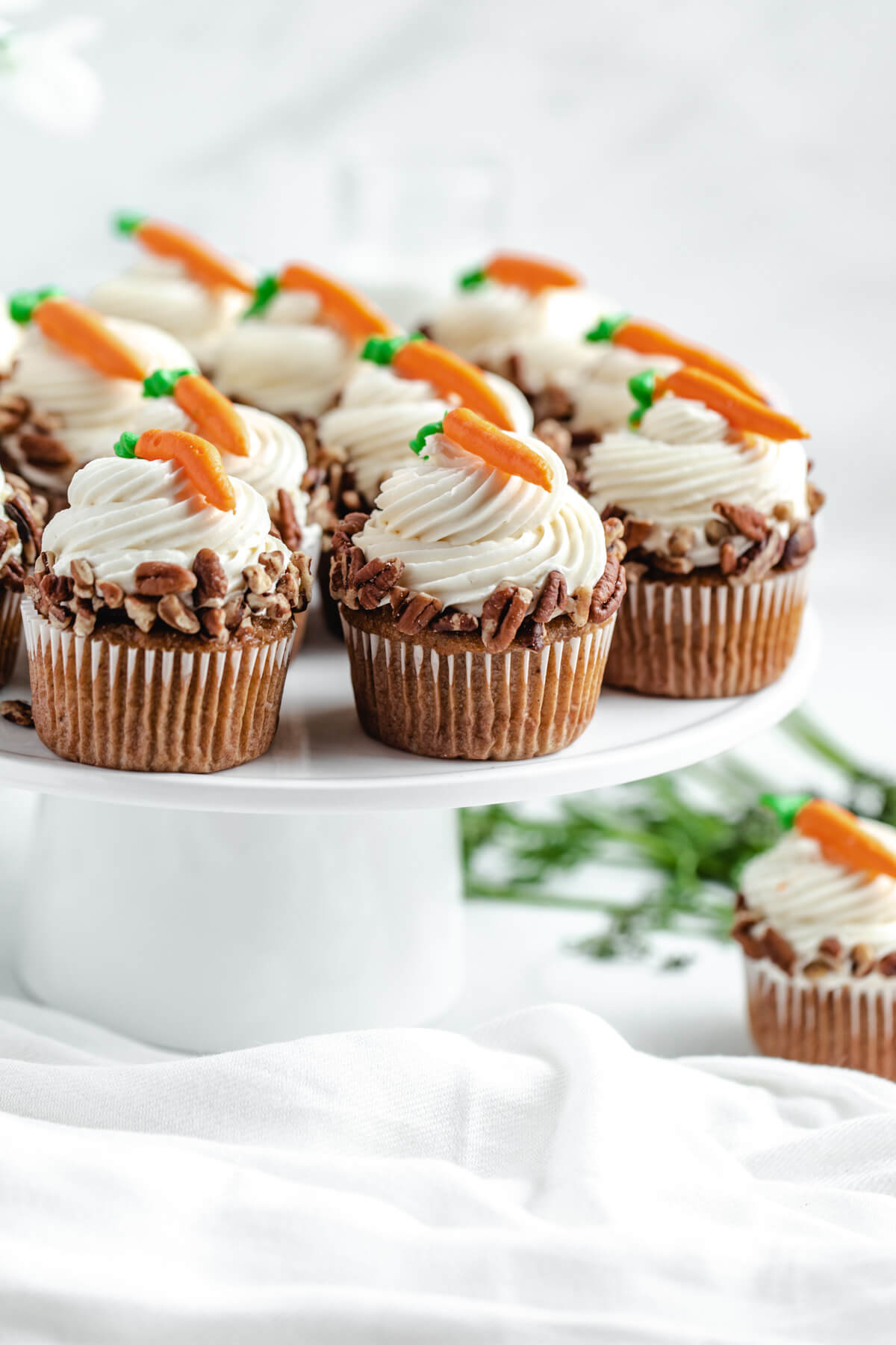 carrot cupcakes on a white cake stand