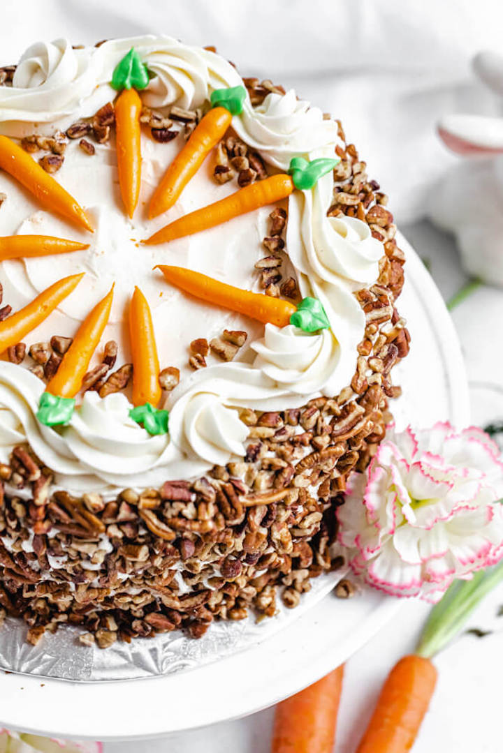 close up of cake on a cake stand with a flower on the side