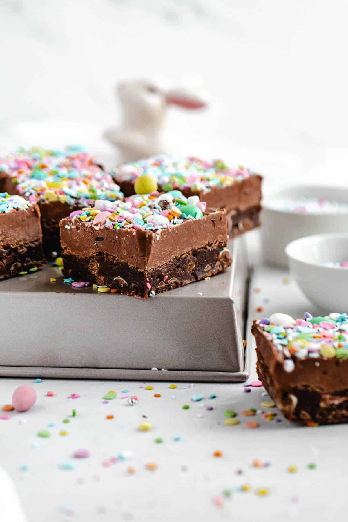 fudge topped brownies on a square cake pan 