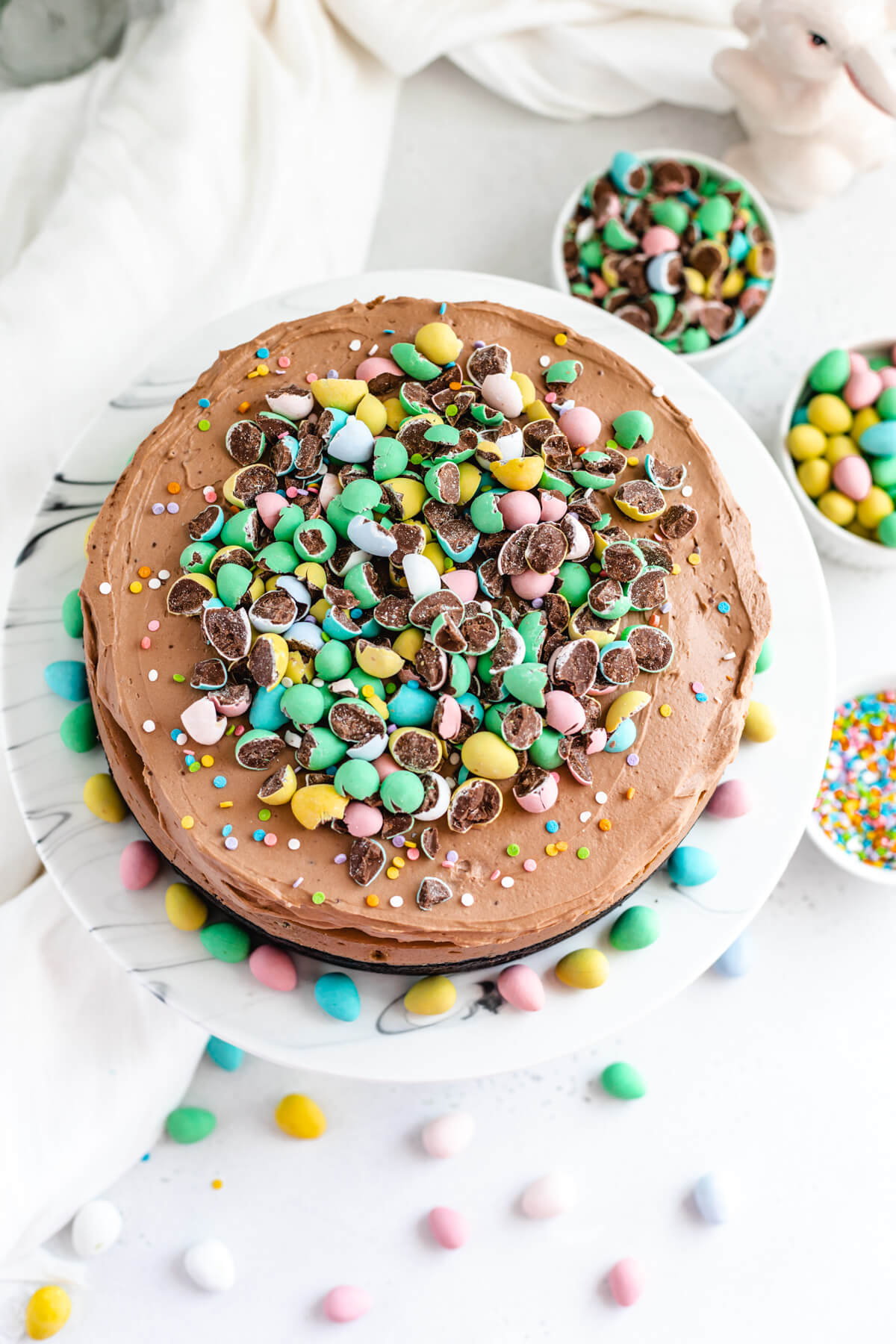 top of cheesecake on cake stand with mini chocolate eggs