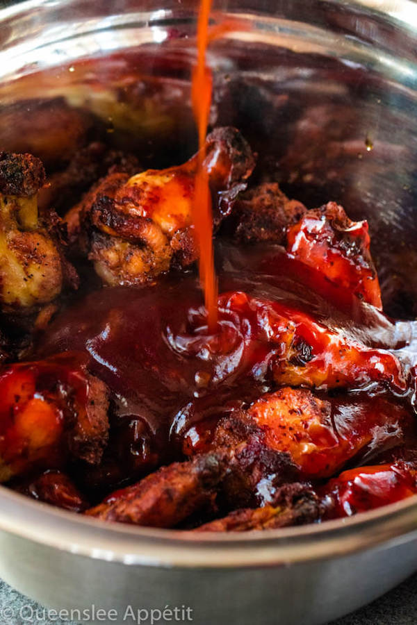 Pouring Honey BBQ Sauce on top of Baked Chicken Wings