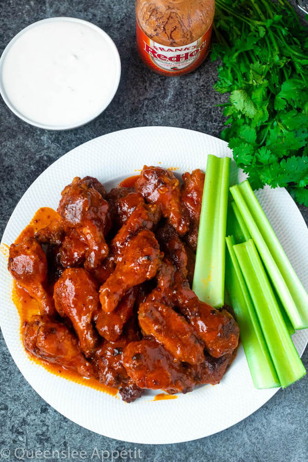 Crispy Baked Buffalo Chicken Wings with celery sticks and blue cheese dip on the side