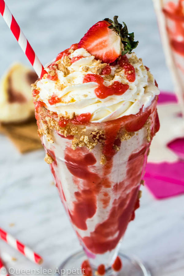 Strawberry Cheesecake Milkshake with Cream Cheese Whipped Cream and strawberries on top